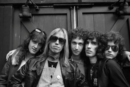 Tom Petty’s Original Heartbreakers Reunite at the Ryman, With Chris Stapleton Singing in His Place Black and white 1970s portrait of the five original members of Tom Petty and the Heartbreakers standing together against a wooden door, Tom Petty in sunglasses at the center