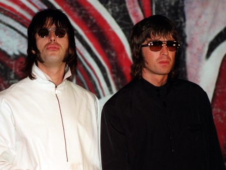 Oasis Object as 100 Hours of Private Gallagher Tapes Head to £1.6m Auction Liam and Noel Gallagher of Oasis standing side by side in sunglasses in the 1990s, Liam in a white jacket and Noel in a black jacket, in front of a painted backdrop