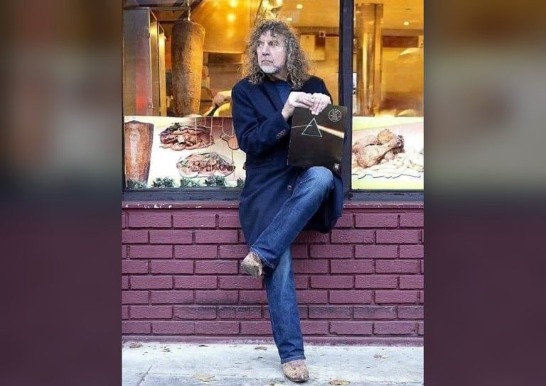 Robert Plant on a street holding records