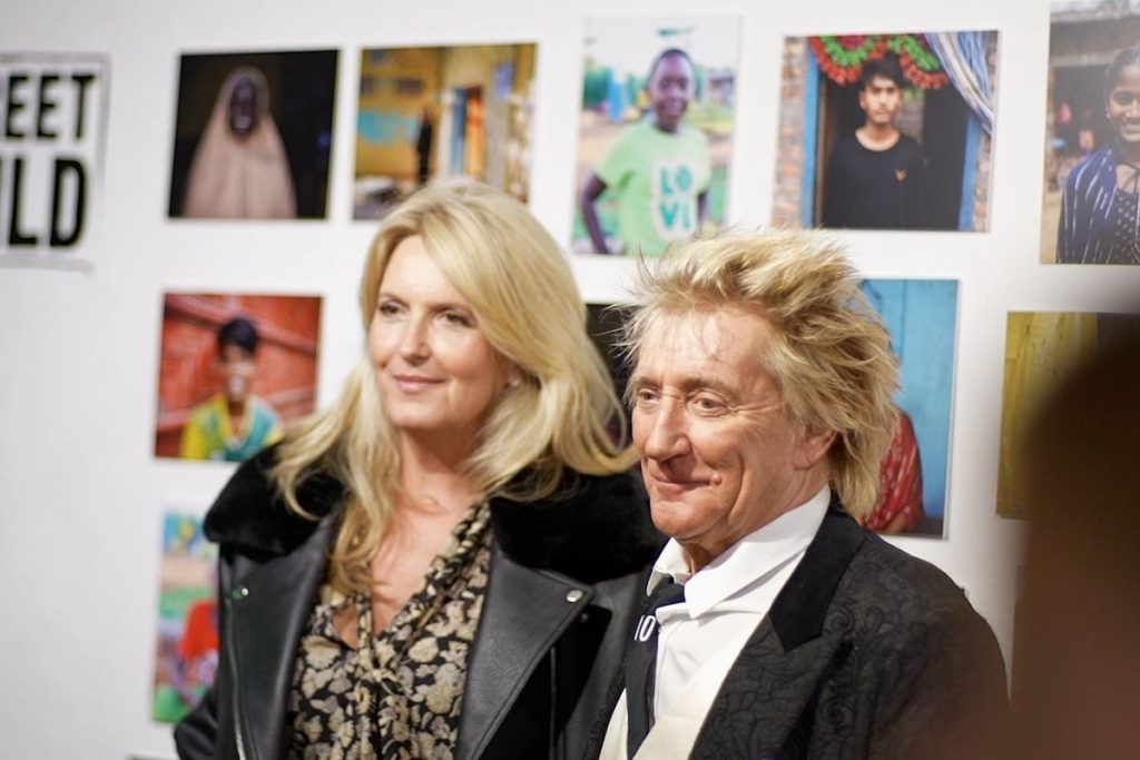 Penny Lancaster: Rod Stewart Is ‘Back in the Gym’ and Will ‘Come Back Stronger Than Ever’ After Heart Operation Rod Stewart and Penny Lancaster standing together in front of a wall of photographs at a Street Child exhibition