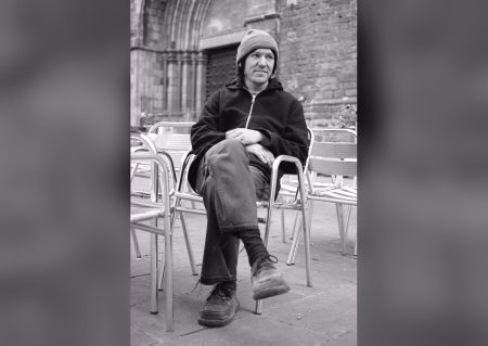 Elliott Smith archival portrait seated outside a cathedral