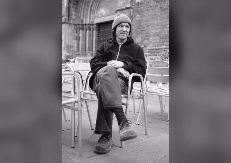 Elliott Smith archival portrait seated outside a cathedral