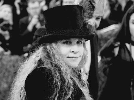 Stevie Nicks’ Brother Christopher Dies at 72 After Private Cancer Battle Stevie Nicks wearing a black top hat with a veil on a red carpet, photographed in black and white