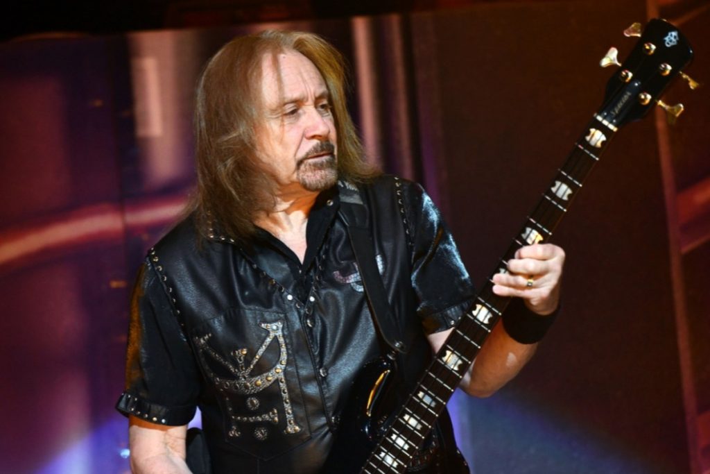 Judas Priest Bassist Ian Hill Retires After More Than 50 Years, Citing Advanced Arthritis Ian Hill of Judas Priest playing bass on stage in a studded black leather shirt