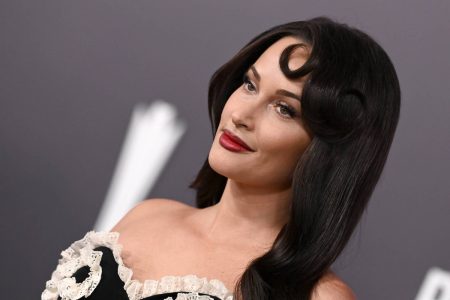 Kacey Musgraves Fires Back at Kristi Noem With Dog Jab After Talarico Concert Dig Kacey Musgraves with long dark hair and red lipstick, smiling on a red carpet