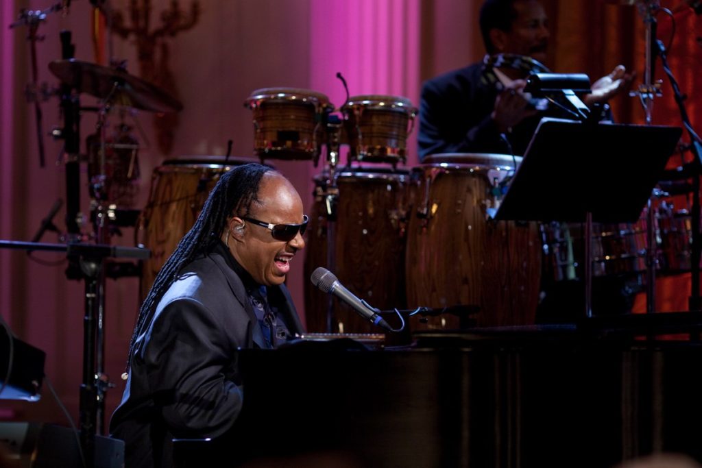 Stevie Wonder Sues to Evict Former Fiancée From the L.A. Home She’s Lived in Rent-Free Since 1988 Stevie Wonder singing at a piano on stage, with conga drums behind him